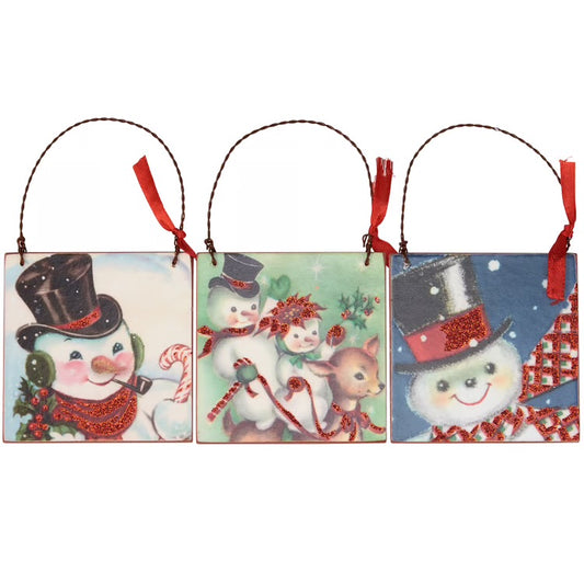 A set of three wooden ornaments from our Christmas Collection displaying three fun scenes of snowmen in a retro art style. Seasonal ornaments feature red glitter details with coordinating red color on the back and red ribbon accent on hanger. Our Retro Snowmen ornament set is easy to hang for display via attached twisted wire hangers. Set comes packaged together in a polybag and tied with ribbon. A fun set of retro ornaments perfect for seasonal display.
DETAILS
Dimensions: 3" x 3" x 0.25"
Material: Wood,