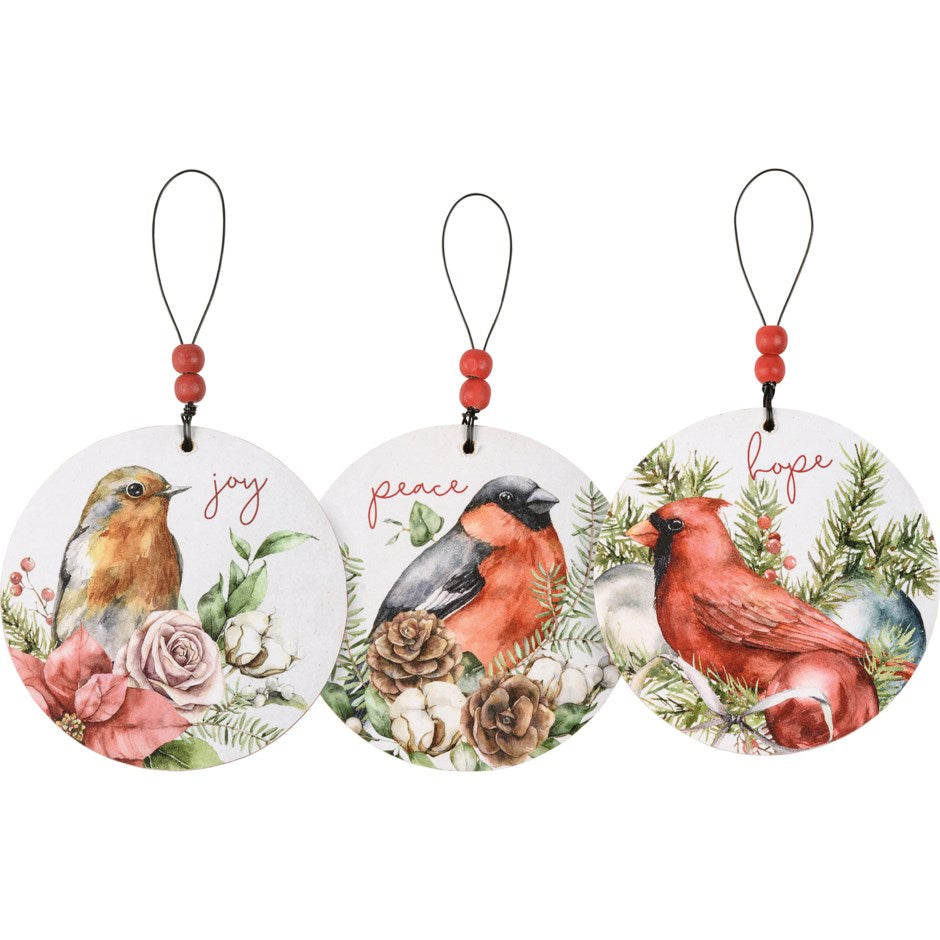 XMAS ORN SET - BIRDS A set of three wooden Christmas ornaments featuring colorful watercolor bird and floral designs with ”Peace ” ”Hope ” and ”Joy” sentiments.