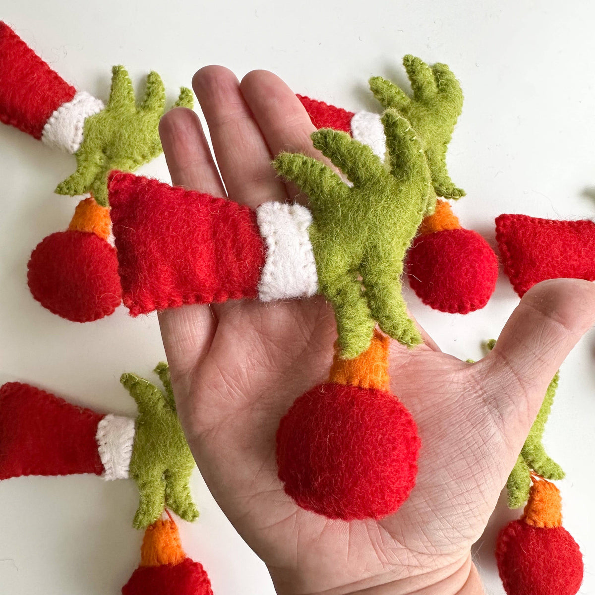Sewing Seeds Play - One Felt Grinch Hand Holding An Ornament 