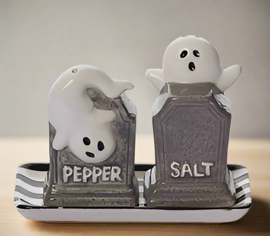 Enhance your Halloween party table with our Haunted Tombstone Salt & Pepper Shakers. These spooky shakers feature tombstones with playful ghosts on top, and come with a matching plate. Made of durable dolomite.