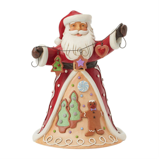 Santa brings the Gingerbread Christmas holiday spirit in this Jim Shore design, holding a string of decorated Christmas cookies. What a joyful smile, Santa presents with his festive garland, while his cloak features a scene of colorful cookies